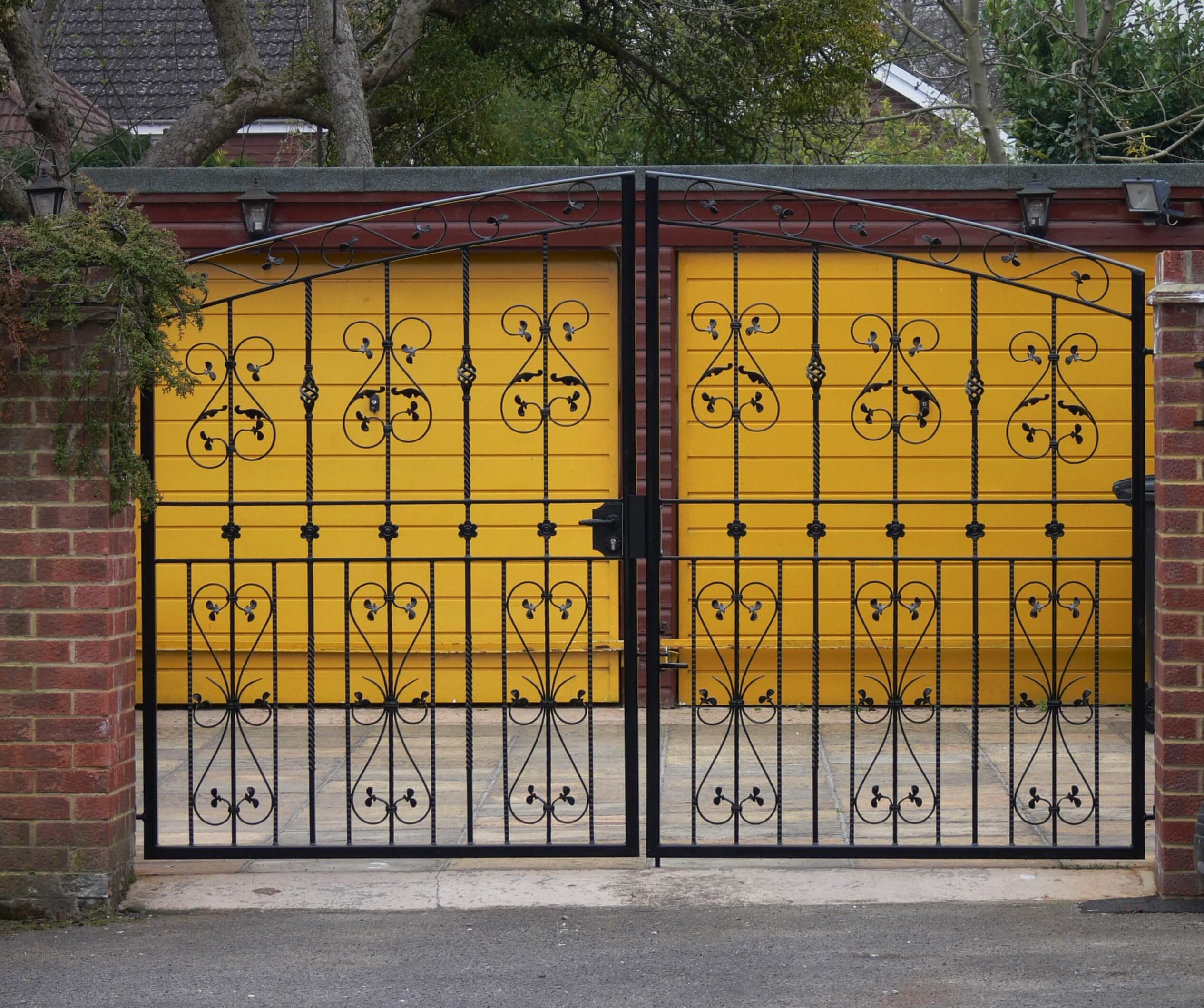 black double decorative gates against yellow garage