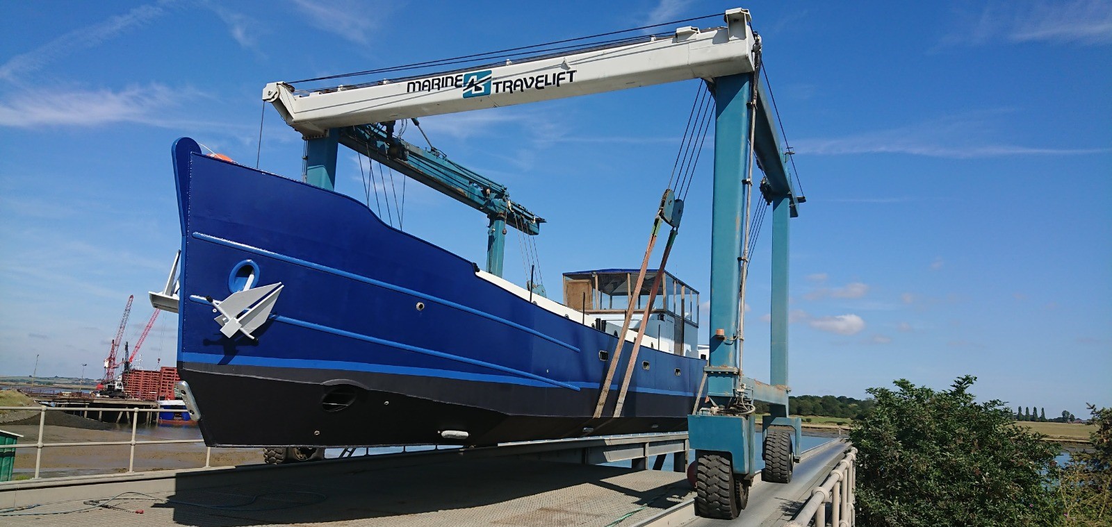 large blue boat lifted at dock